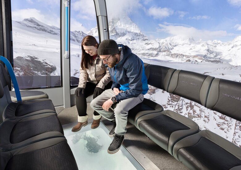 Crystal Ride | © Zermatt Bergbahnen AG Zwei Leute die durch den Glasboden schauen | © Zermatt Bergbahnen AG