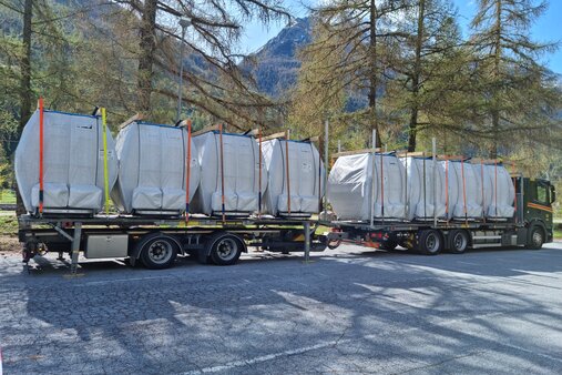 Die "Omega 4" Kabinen beim Umschlagplatz in Täsch | © Zermatt Bergbahnen AG Eingepackte Omega 4 Kabinen auf Lastwagen | © Zermatt Bergbahnen AG