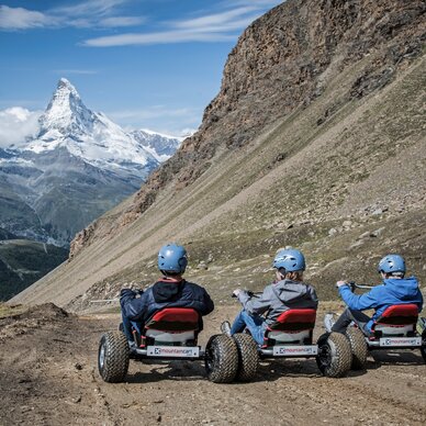 Four friends riding mountaincarts towards the Matterhorn | © Leander Wenger