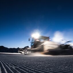 Blurry lights of a PistenBully at night | © Mateusz Bocian Blur of a PistenBully driving by during night shift | © Mateusz Bocian