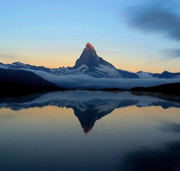 Colourful sunrise at lake Stellisee with the Matterhorn reflection on the water | © Zermatt Bergbahnen AG